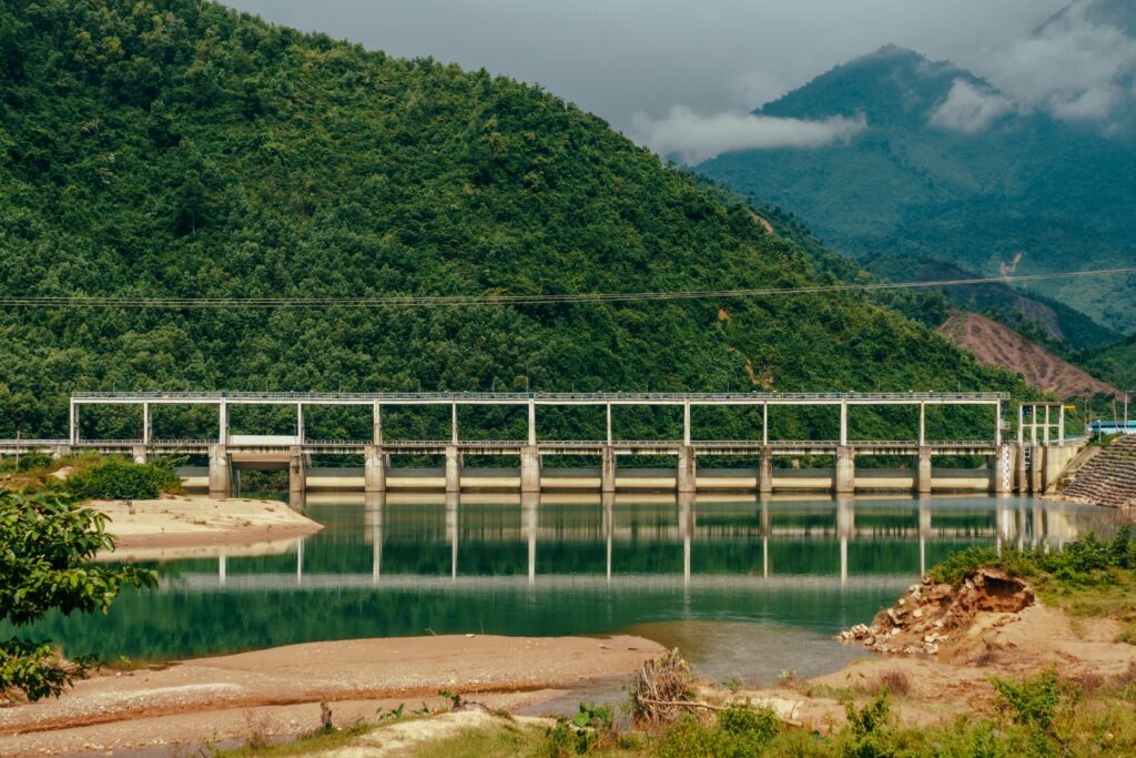 a bridge over a body of water with a mountain in the background