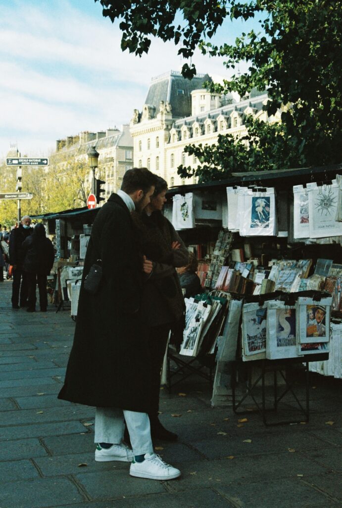 a man and woman standing next to each other on a sidewalk